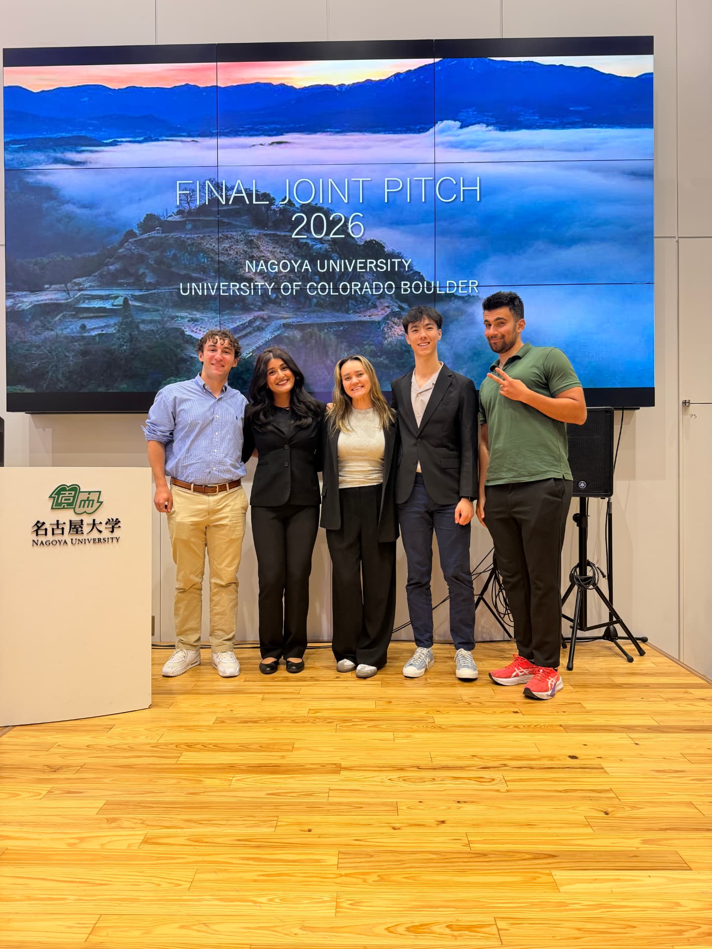 Niraja and her project teammates standing in front of the Final Joint Pitch 2026 screen at Nagoya University
